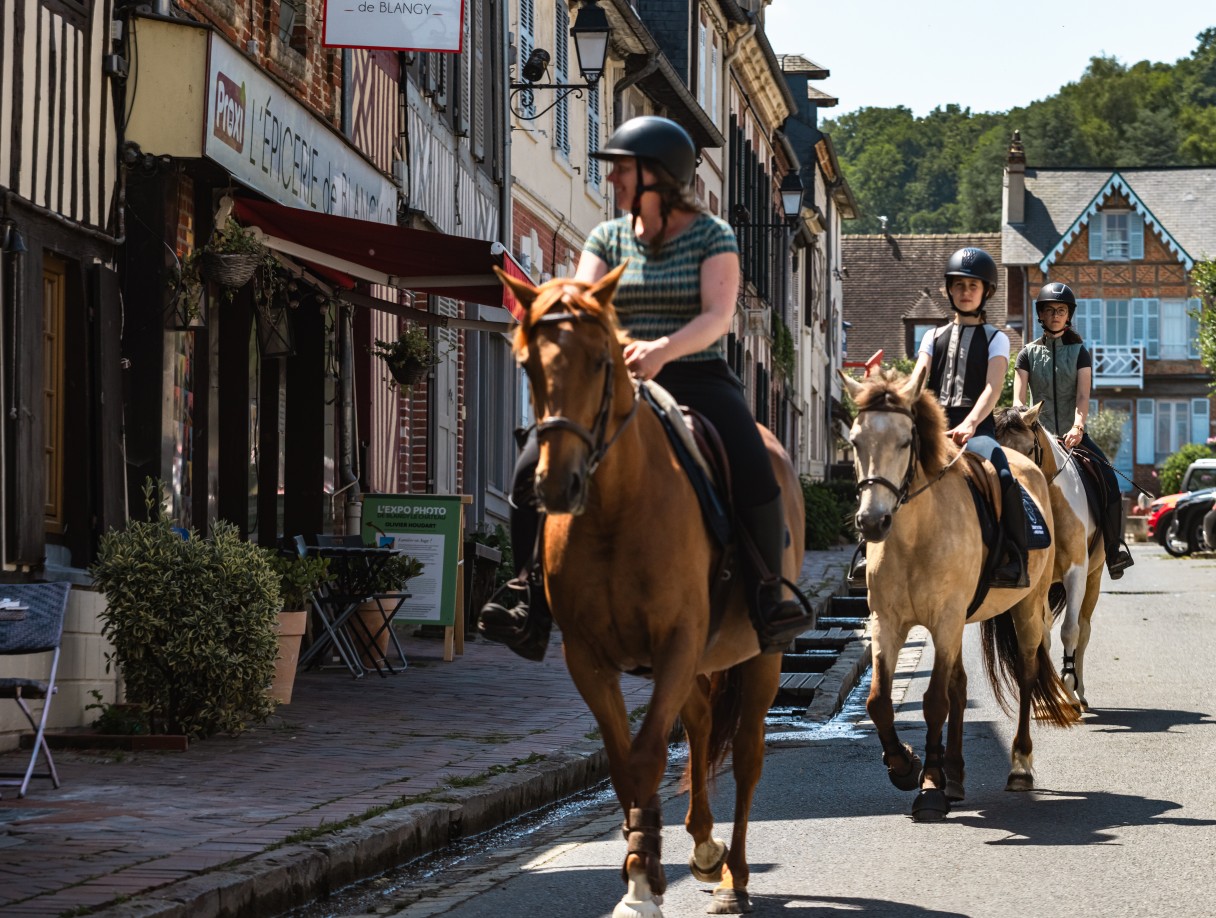 Cavaliers en balade à cheval dans les rues de Blangy-le-Château, près du Brévedent dans le Pays d’Auge.