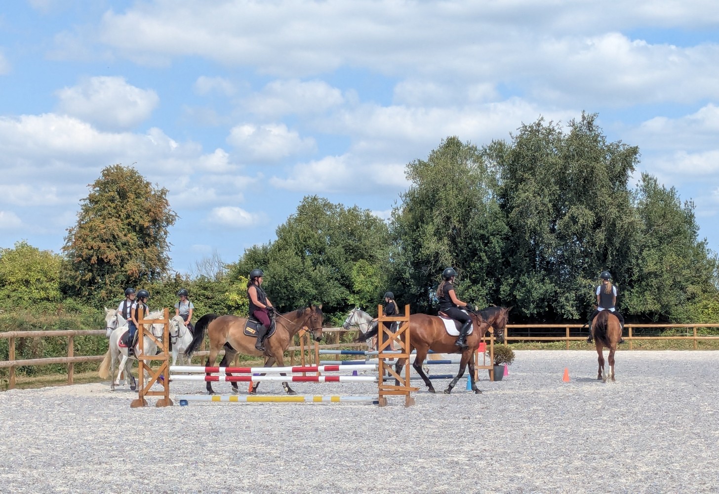 Cours d’équitation en groupe – Le Brévedent Cavaliers en cours d’équitation dans la grande carrière du centre équestre du Brévedent, en Normandie.