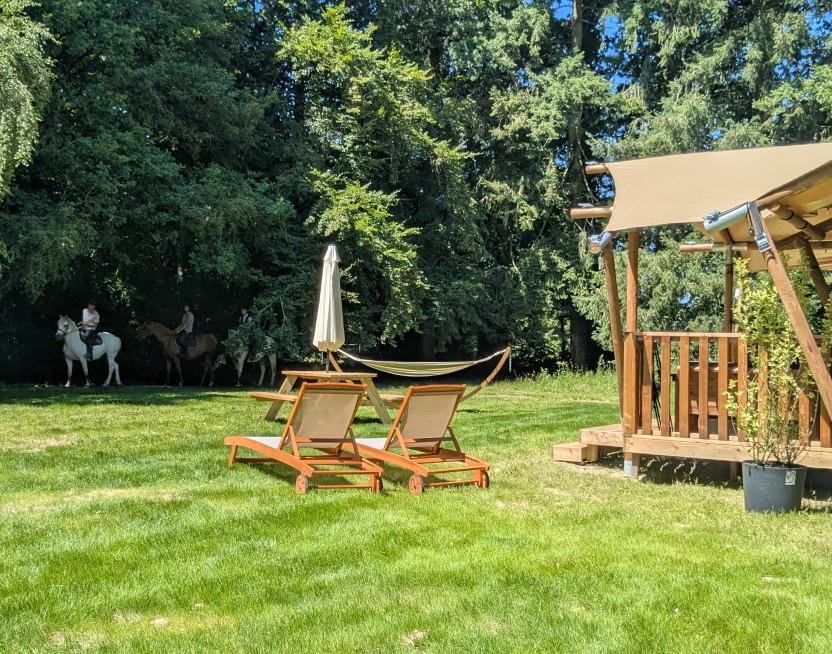 Séjour équitation et détente en Normandie – Natur&Lodge Le Brévedent Hébergement Natur&Lodge avec cavaliers en arrière-plan au centre équestre du Brévedent près de Cormeilles.